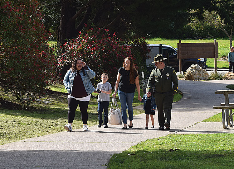 Faviola Del Real, widow of Sgt. Damon Gutzwiller, walks to the memorial at Willowbrook Park with their two children.